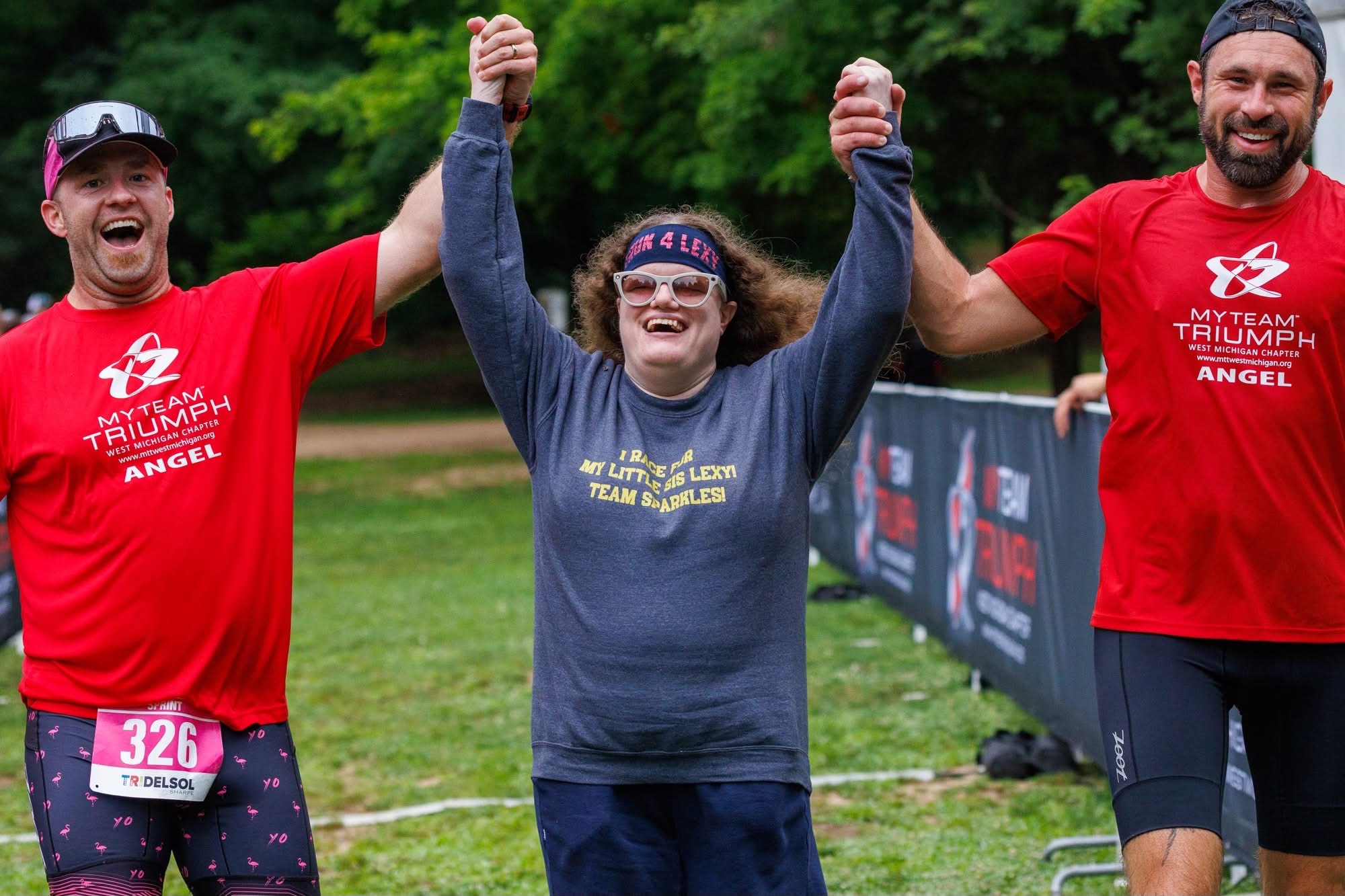 Athletes celebrating with arms raised at the finish