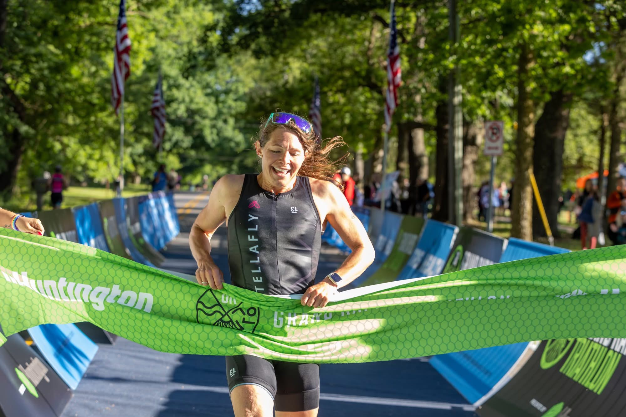 StellaFly triathlete breaking the finish line tape