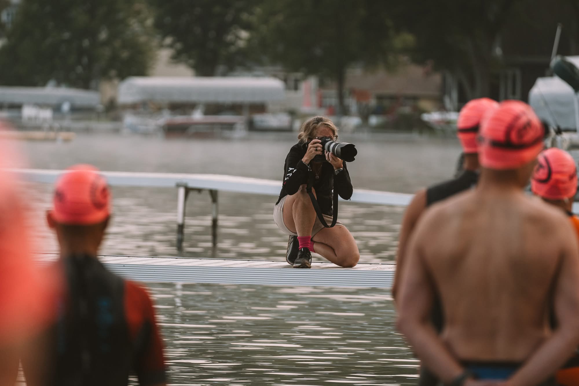 Photographer kneeling on the dock at a triathlon swim start