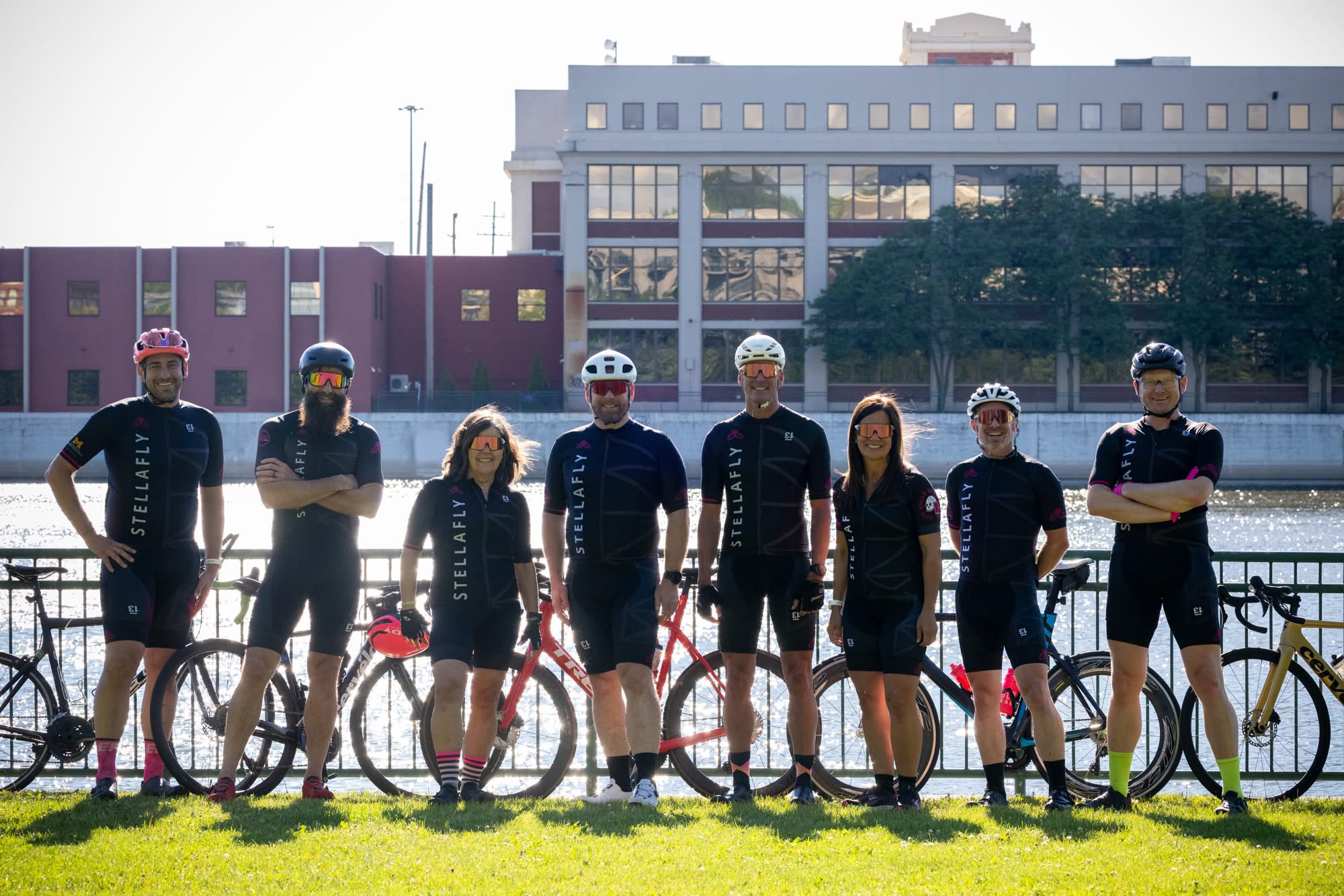 Full StellaFly cycling lineup posed along the river