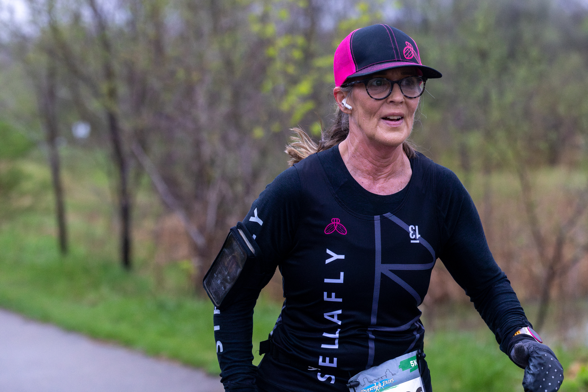 A StellaFly runner moving down a wooded path during a race