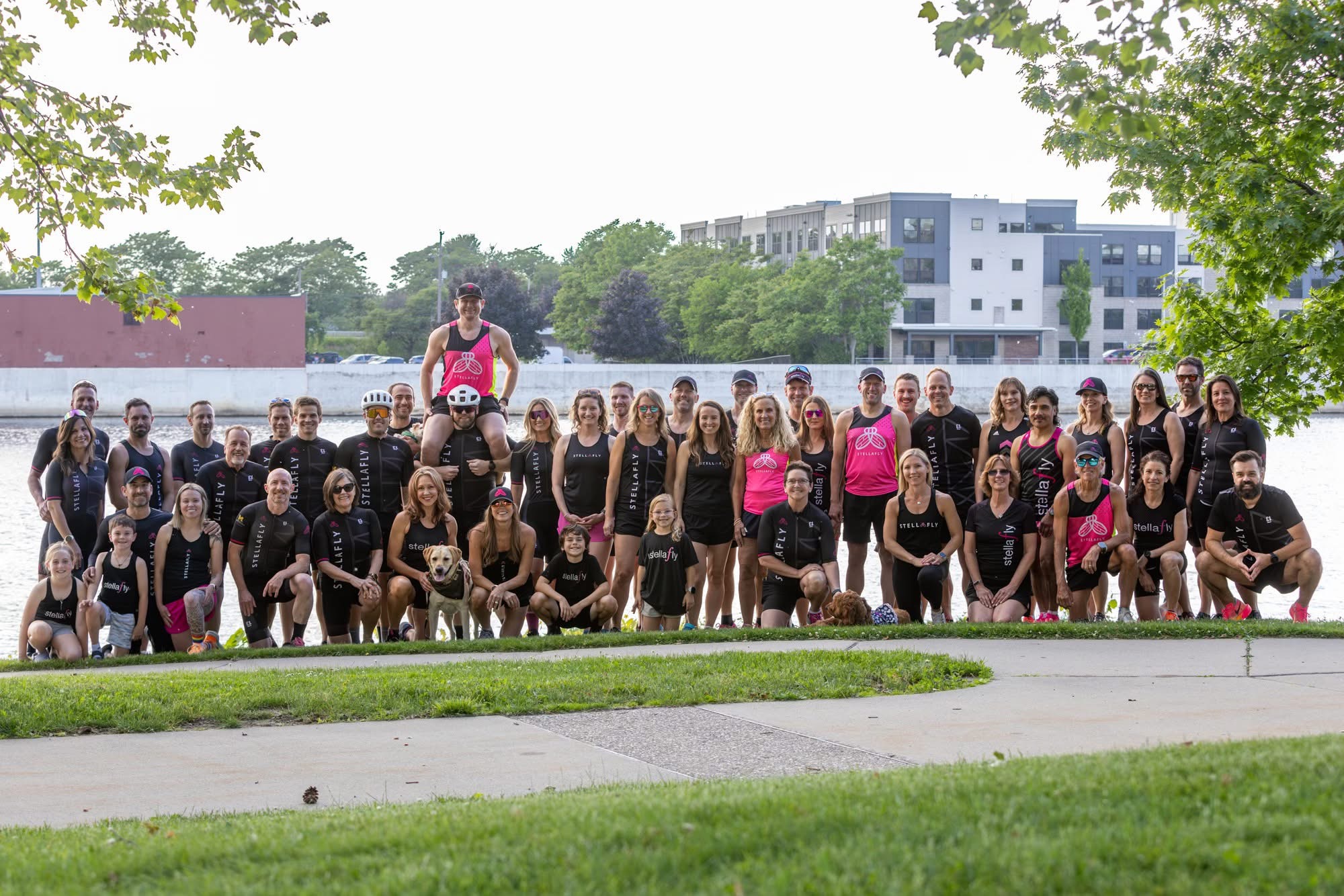 Team StellaFly riders, runners, and triathletes gathered together along the river